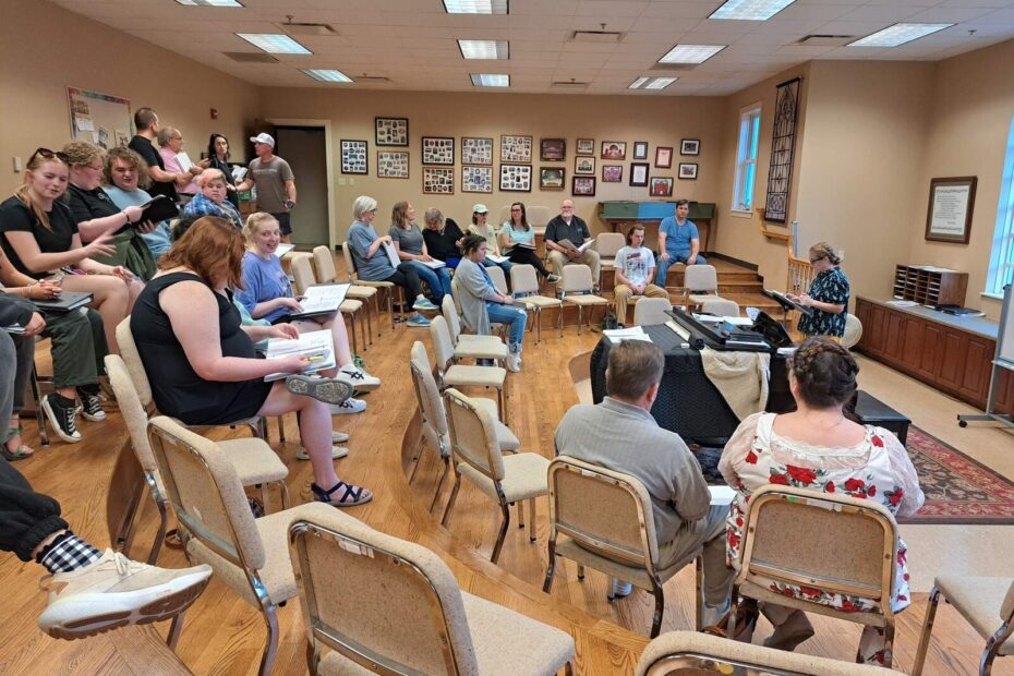 Cast members chatting and preparing, scripts in hand, on the first day of rehearsals