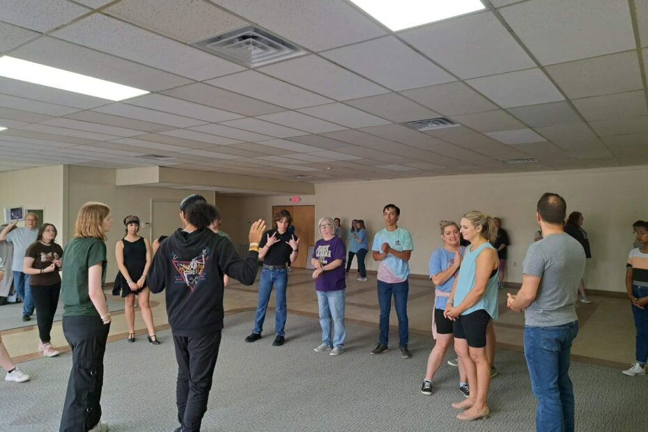 Performers listening to instruction while refining Gavotte choreography
