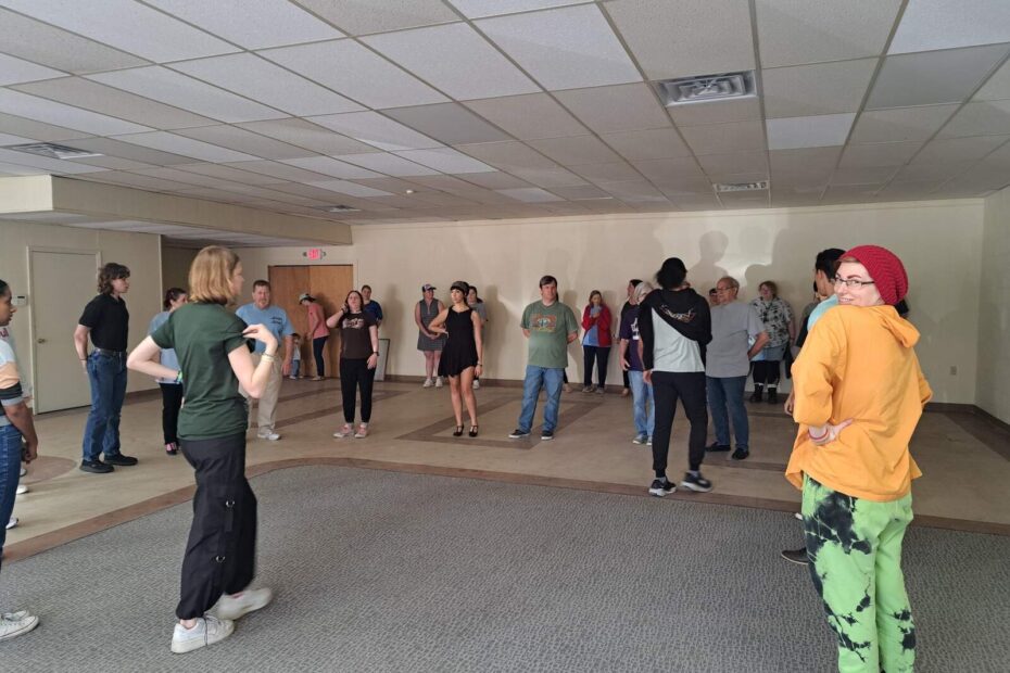 Performers listening to instruction while refining Gavotte choreography