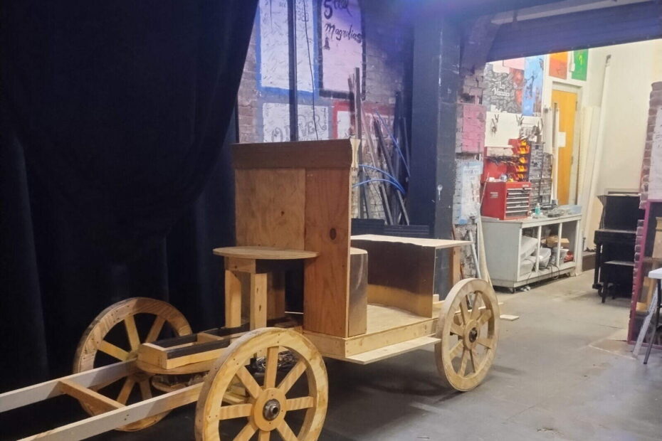 Wooden carriage in theater backstage area.