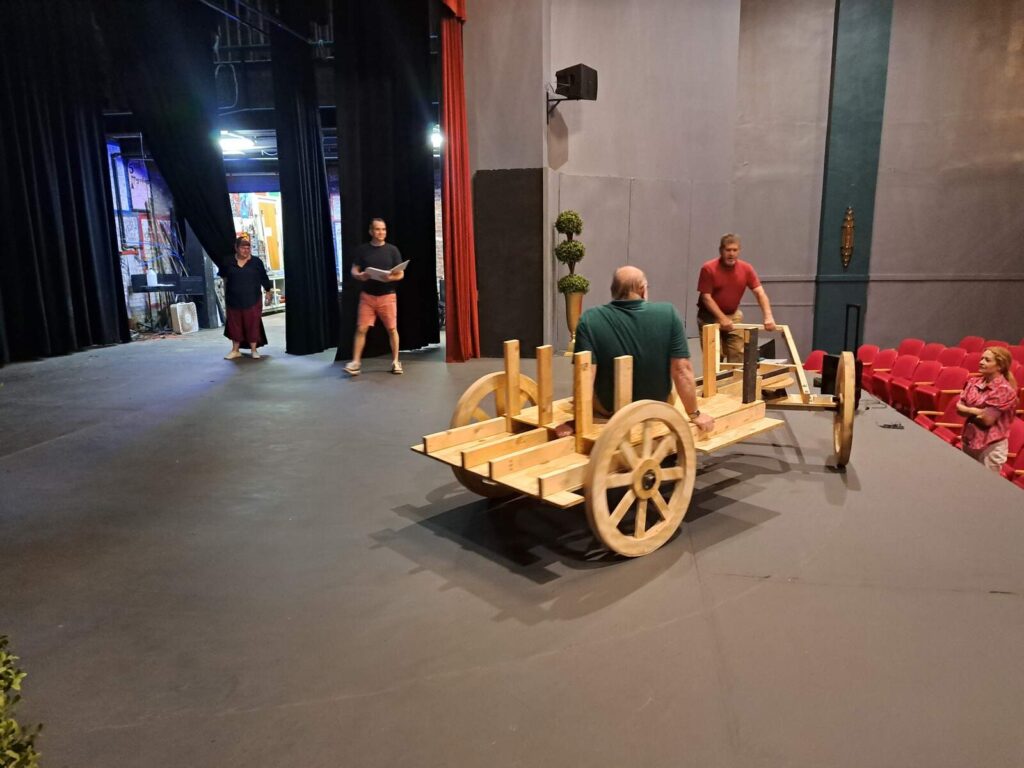 Wooden carriage tested by cast members on stage.