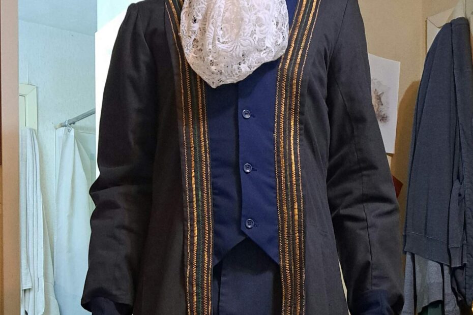 A man in a royal court costume with a lace jabot and dark embroidered coat.
