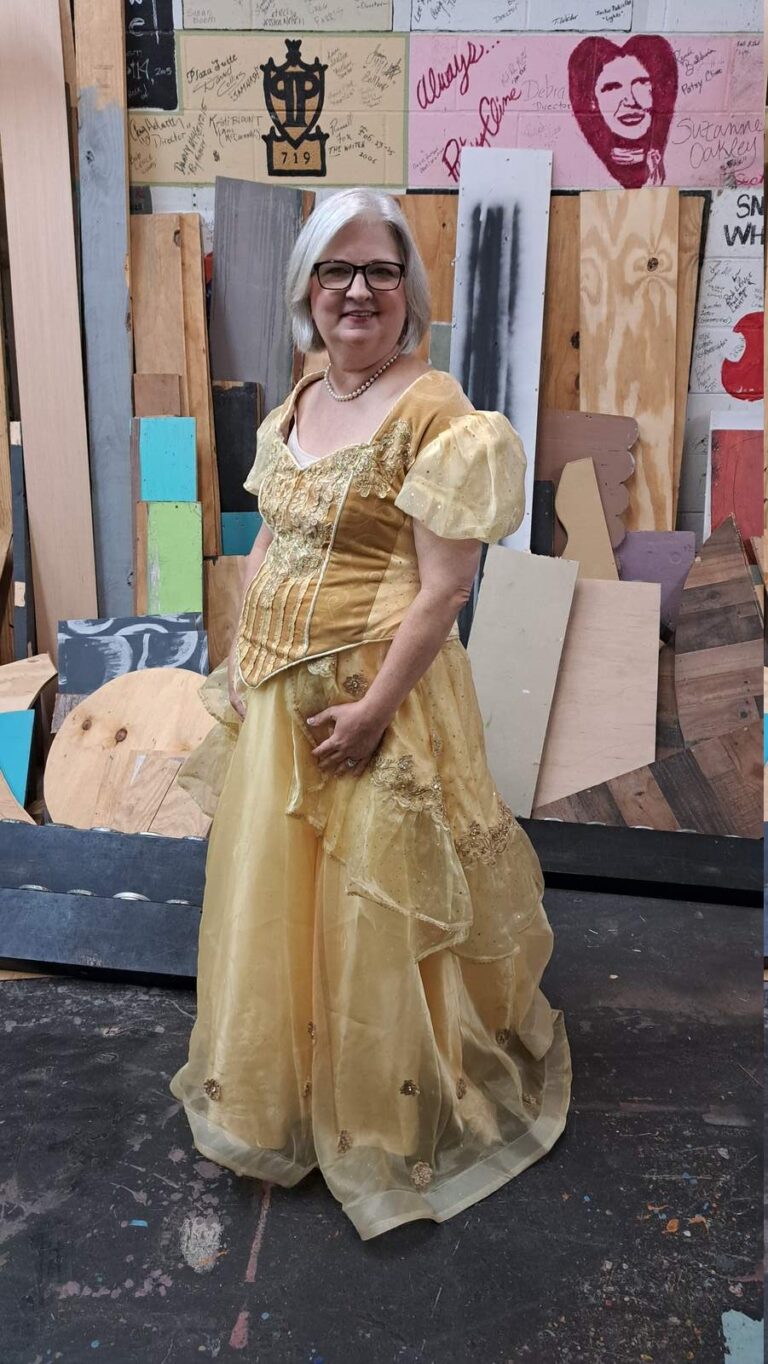Performer in shimmering gold ball gown with puff sleeves and corseted bodice
