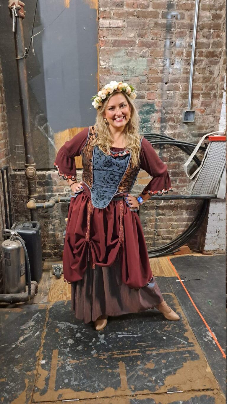Smiling performer with flower crown in burgundy town costume
