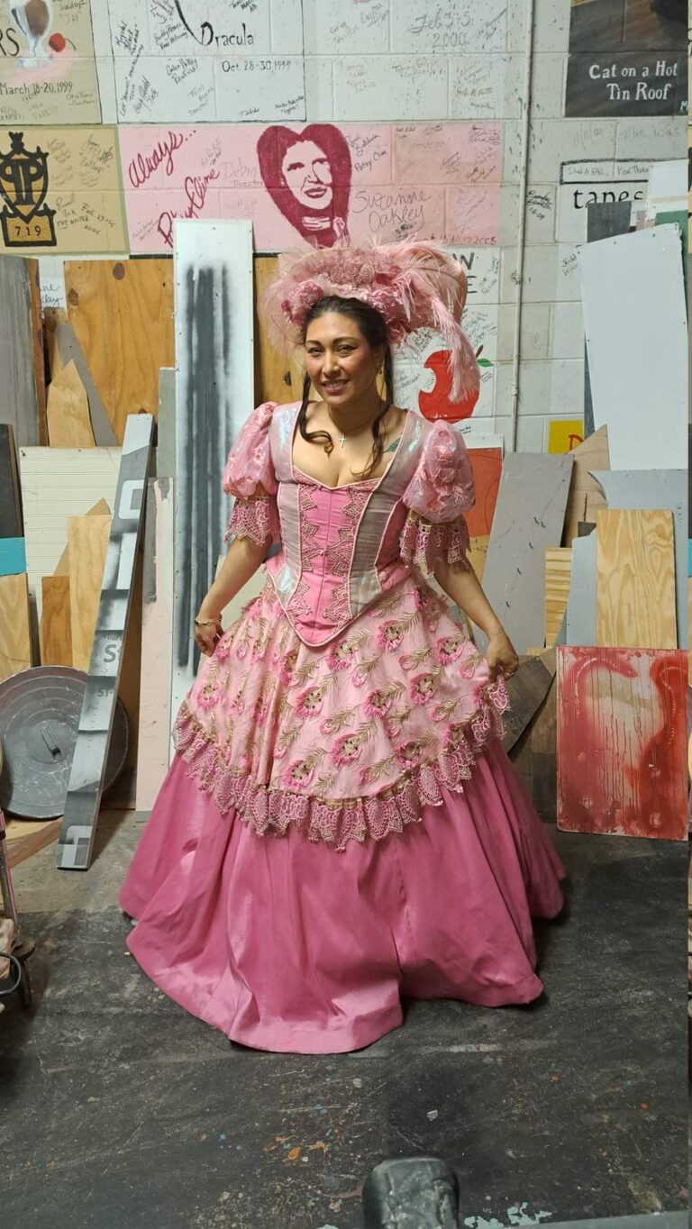 Performer in ornate pink dress with feather headdress