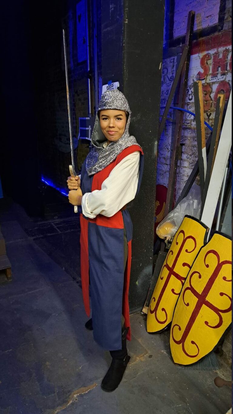 Costumed guard in chain hood lifts practice blade