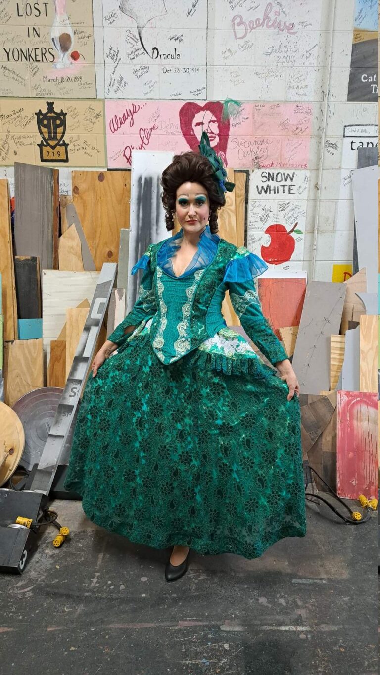 Performer in deep green lace gown poses with attitude