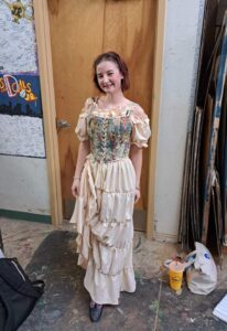 Performer in floral corset top and tiered cream skirt