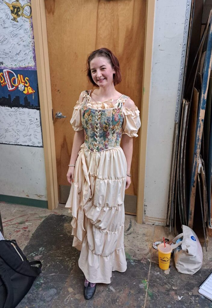 Performer in floral corset top and tiered cream skirt